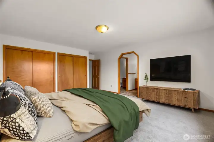 The primary bedroom with plenty of closet space, PLUS a walk in closet through the arched doorway, 2 sinks and a new step in shower. (virtually staged)