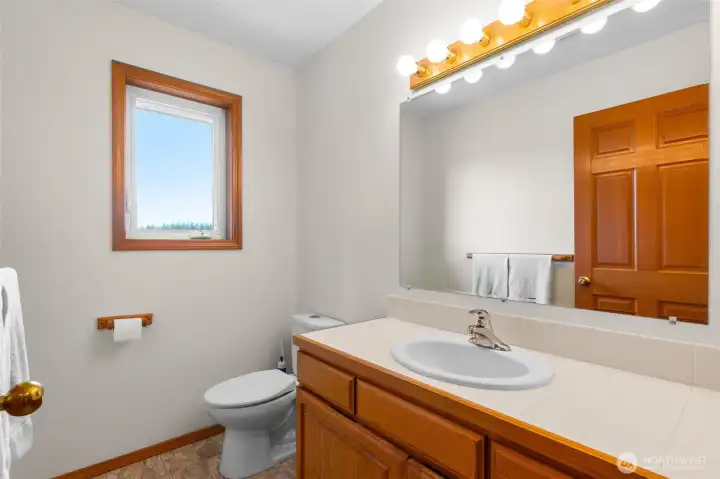 The half-bath off of the den/office or bedroom on the kitchen side of the home.