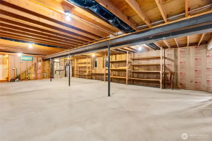 The basement looking toward the furnace and water heater, and the stairs to the main level.