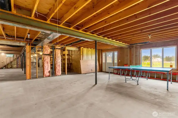 The far side of the basement with windows and door to the exterior.