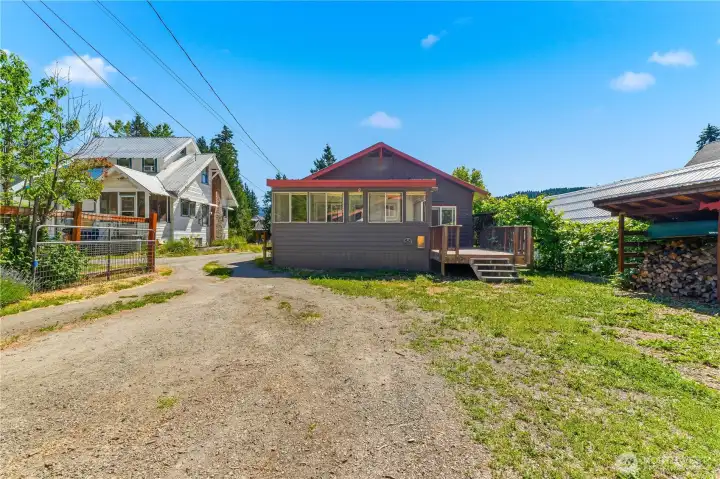 Back of house, enclosed utility room, deck, & driveway to garage from garage entrance.