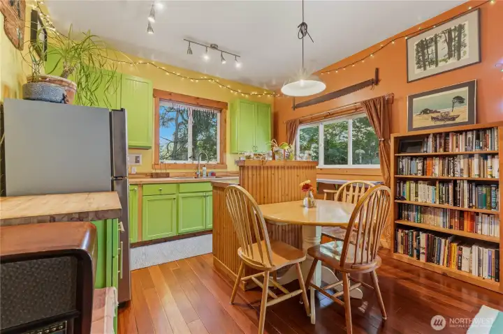 Flex space behind garage has beautiful wood floors, built in bookcases, & a refrigerator.