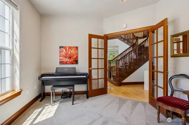 Just off of the entry foyer, glass pane French doors lead to the office/den, which doubles nicely as a music salon or main floor bedroom option.