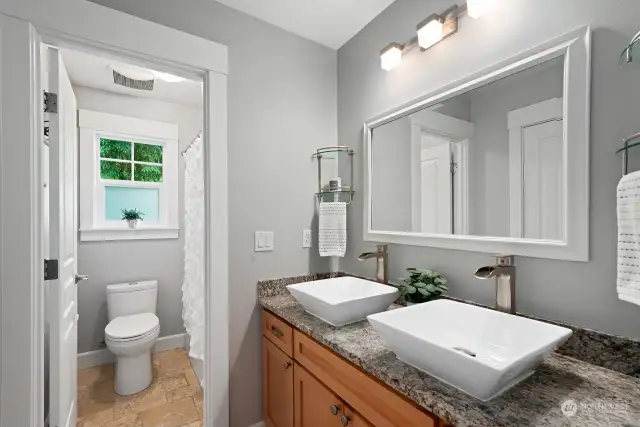One of two full bathrooms on the upper level.  Fixtures, sinks and granite countertop installed in 2018.