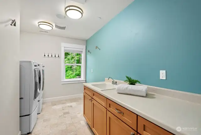 Laundry room with generous countertop and cabinets.  Washer and dryer stay with the home.