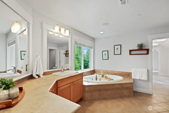 Luxurious primary bathroom with soaking tub, dual sinks and an abundance of cabinets and counter space.