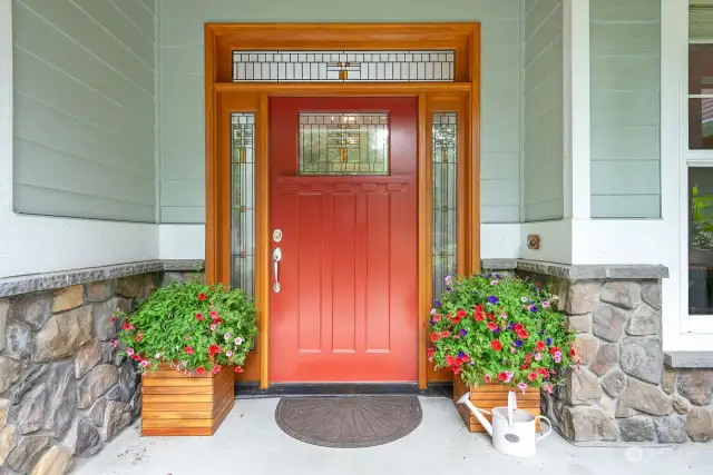 Welcoming entry with gorgeous custom front door and covered veranda.