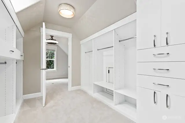 Large primary walk-in closet with skylights and custom built-in closet organizers.