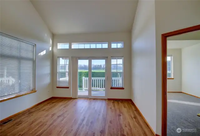 Living room with French doors leading to deck and primary bedroom doorway