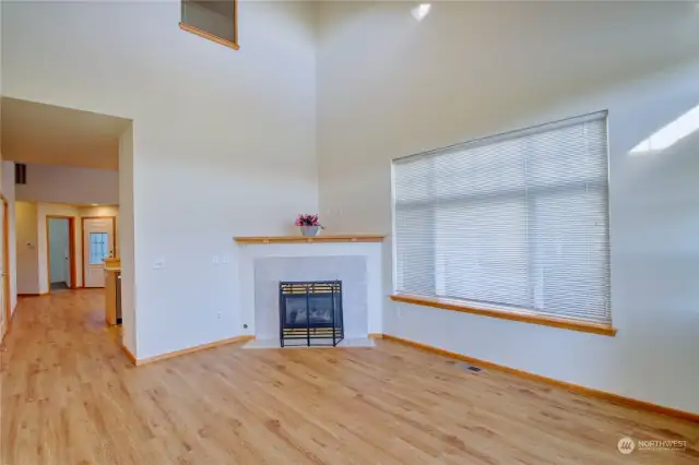 Living rm with fireplace looking through to kitchen dining area