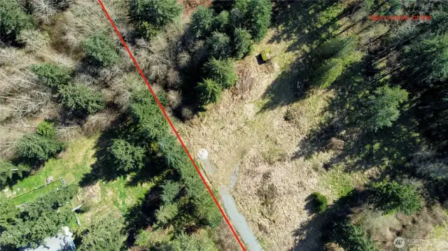 Approximate lot line adjacent to driveway and cleared area