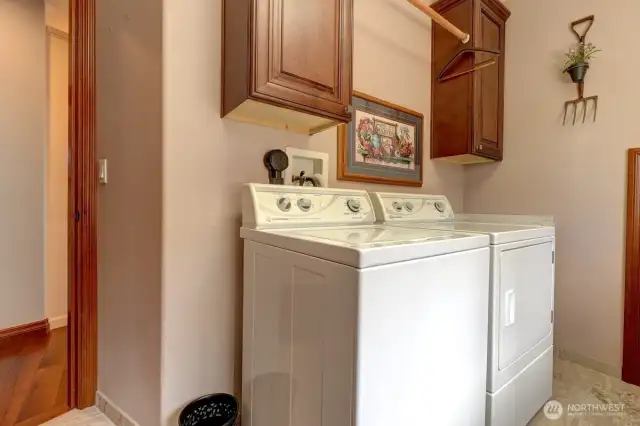 Laundry room has storage and rack for hanging clothes.