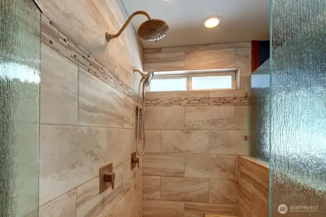 Large tiled shower in primary bathroom.