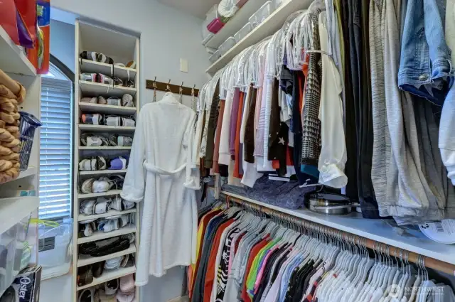 Walk in primary closet has lots of storage.