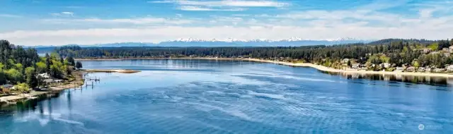 View of Olympic Mountains to the North from Fox Island bridge with Gig Harbor to the right.