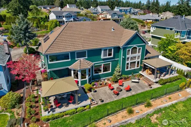 View of back of property which boasts a Trex deck and two gazebos in a fully fenced back yard for your relaxing pleasure.
