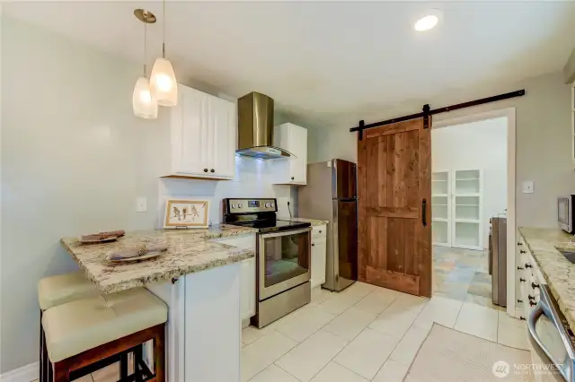 Another view of the kitchen with barn door leading to the utility room. All appliances included!