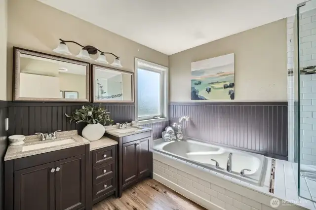 Updated Primary Bathroom  Relax and unwind in the beautifully updated primary bathroom, featuring a luxurious soaking tub and a stylish tile shower with a sleek glass enclosure—combining comfort and modern design.