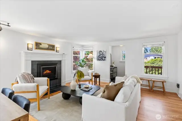 Functional living room with new paint, gas fireplace, hardwood floors and natural light pouring in.