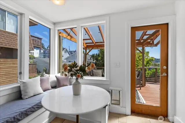 Cozy and bright informal kitchen nook with built in bench seating and access to the covered deck.