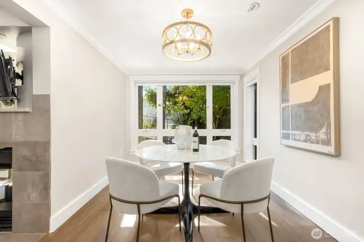 West-facing dining room with large windows that flood the space with natural light, even on the ground floor. A modern light fixture and open flow to the kitchen and living room make this a warm and welcoming spot to gather.