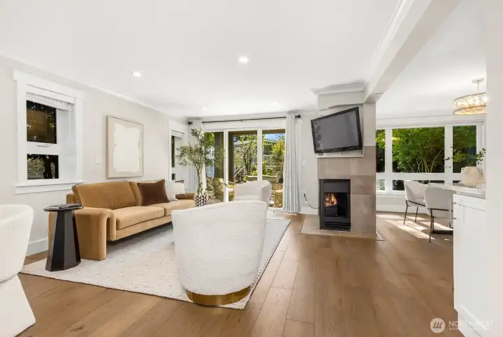 Stylish west-facing living room anchored by a cozy fireplace and sliding glass doors to the patio. Oversized windows bring in abundant afternoon and evening sunshine, making the space bright and cheerful.