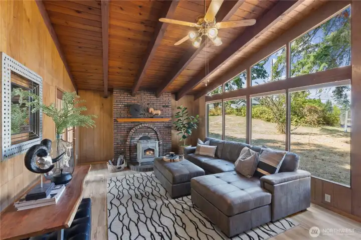 STEP DOWN INTO THE LIVING ROOM WITH LARGE WINDOWS/WOOD BURNING FIREPLACE