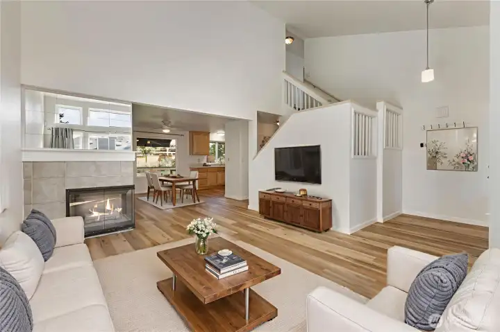 Virtually staged living room with vaulted ceilings and new flooring throughout.