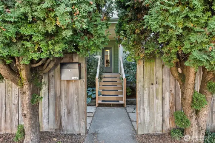 Hidden, private entry behind trees and fully fenced yard.