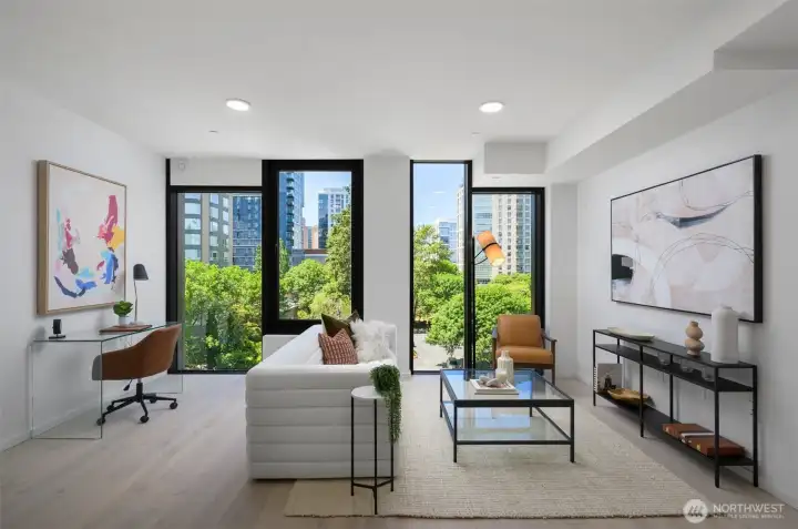 Living area features operable floor-to-ceiling windows, engineered hardwoods, ceiling Mitsubishi mini-split, and ample space for a home office.