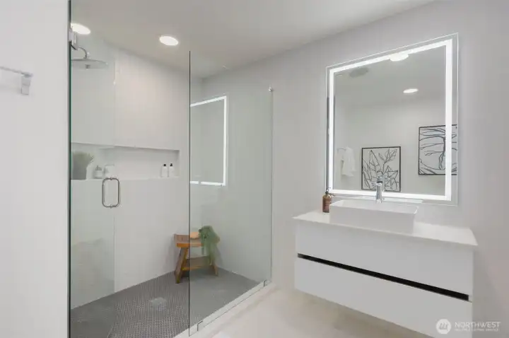 Bathroom features a ceramic tile walk-in shower and a floating quartz vanity with a daylight mirror.