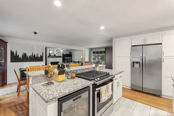 Open-concept kitchen with gas range, wine fridge, generous prep space, and seamless flow into the main living area.