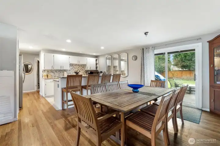 Dining Room -   Spacious dining area with hardwood floors, breakfast bar seating, and sliding door access to the backyard patio.