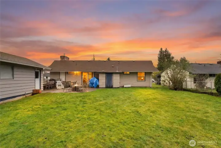 Rear exterior view highlights the expansive backyard, patio space, and easy access to outdoor living.