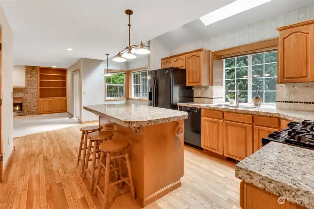The spacious kitchen features lots of counter space with granite tile. The kitchen is light and bright with a skylight and windows that let nature shine through