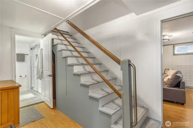 Staircase to the lower level that's currently be used as a stand alone suite with it's own convenience kitchen, three quarter bathroom and large room with wood burning fireplace.