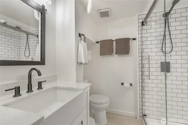 Classic and modern, lower level 3/4 bathroom with white subway tile.