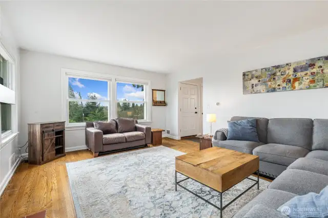 Spacious living room with Oak hardwood floors and modern insulated double hung windows.