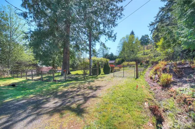 A driveway leads to a gated entry.
