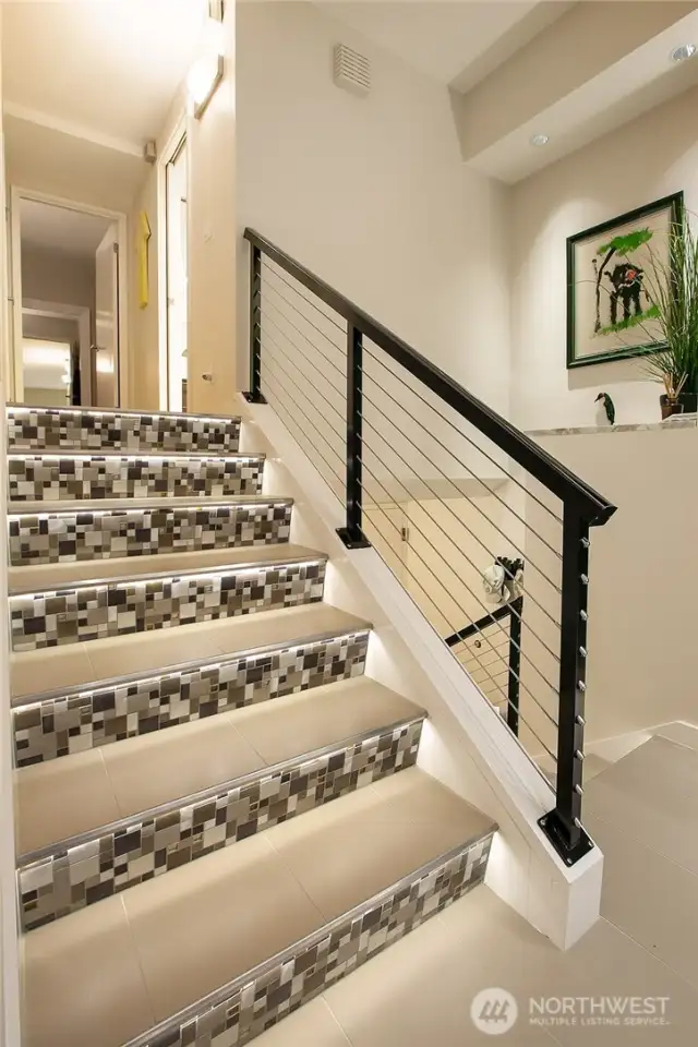 Modern mosaic tilework and steel railings on the stairs...