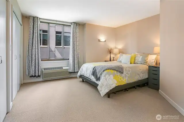 The main bedroom on the private upper level features ample closet space and A/C wall unit.