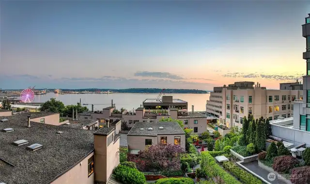Pink sunset views overlooking Puget Sound and manicured courtyards below.