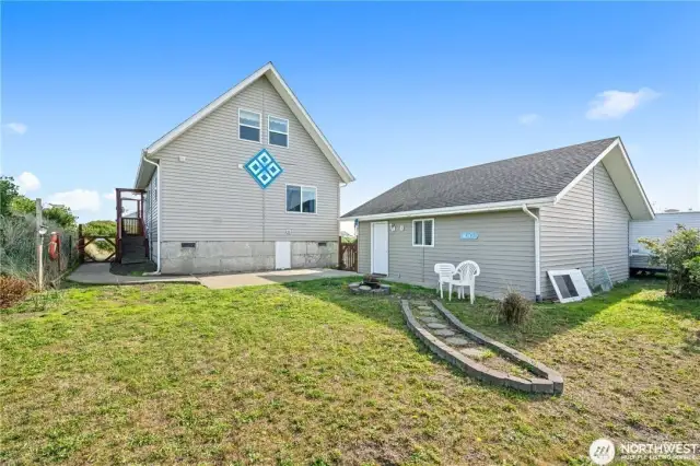Back yard aread with detached two vehicle garage and also side of garage is set up for mobile home connection