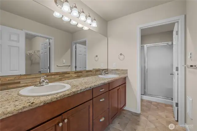Primary En Suite Bath w/Extra Long Dual Sink Vanity w/Granite Counters and Tile Backsplash. Shower and Toilet are separated.