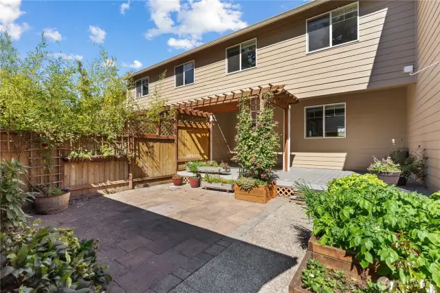 Lovely Courtyard-Style backyard w/Covered Trex Deck and Paved Walk to the Garage. Planters offer above ground gardening space.