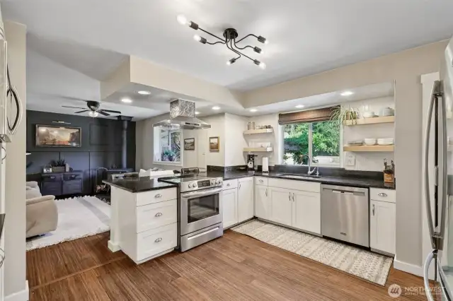 Stainless steel appliances and range hood add to the modern elegance of the space.