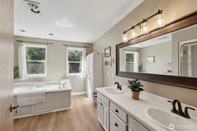 The ensuite primary bathroom features a large soaking tub, separate shower, and double vanity, along with extra built-in storage for linens and toiletries.