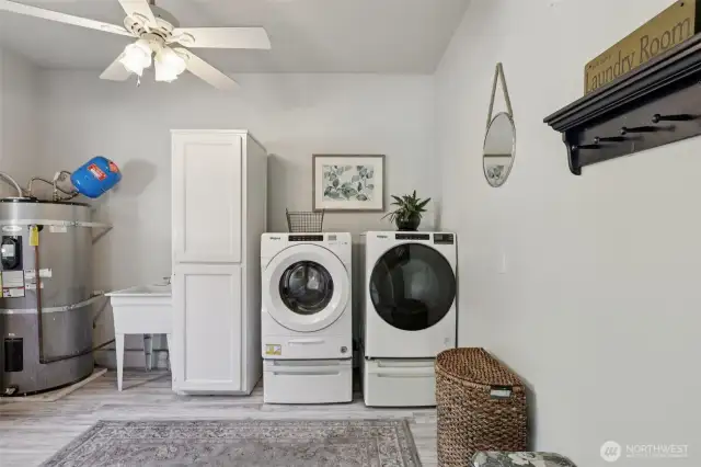 The laundry room has storage, utility sink and the water heater for easy access.