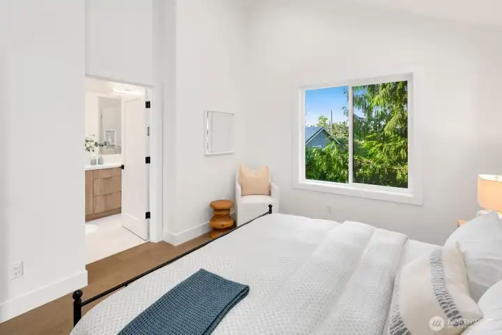 Upper level primary suite has a 3/4 bath, walk-in closet and vaulted ceilings.