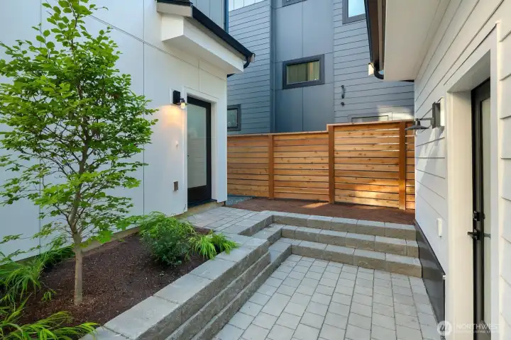 This is the courtyard area between the detached home and the carriage house. The door on the right takes you into the main living room of the detached home. The door on the left is the back entrance to the carriage house.
